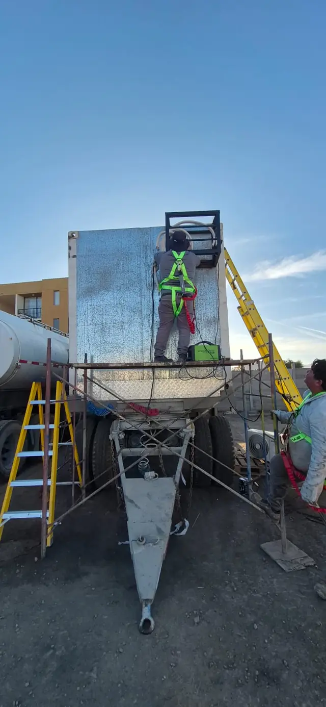 Técnico COAX con arnés instalando estructura para equipo de aire acondicionado